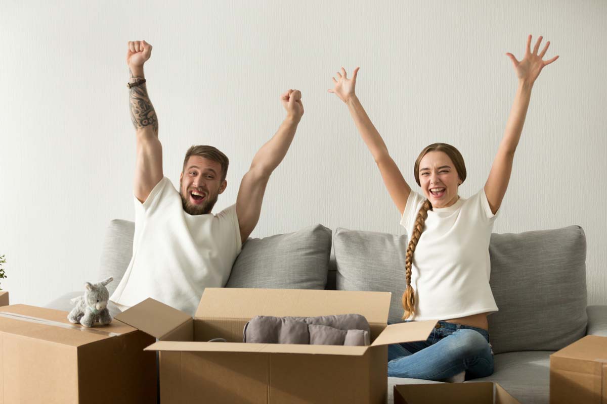 excited-couple-raising-hands-happy-move-new-house_1